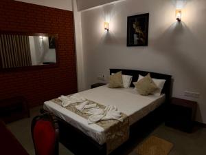 a bedroom with a bed with towels on it at Solar Airport Hotel in Seeduwa +2 photos
