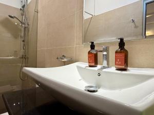 a bathroom sink with two bottles of alcohol on it at Solar Airport Hotel in Seeduwa