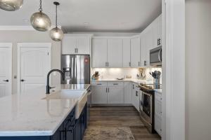 a kitchen with white cabinets and white counter tops at Pool Spa Fire Pit & More at this OKI Escape in Oak Island +43 photos