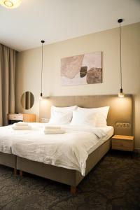 a bedroom with a large bed with white sheets and pillows at Moment in Strzelce Opolskie +70 photos