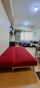 a bedroom with a large red bed in a room at Avida Towers Aspira Studio Condo in Cagayan de Oro