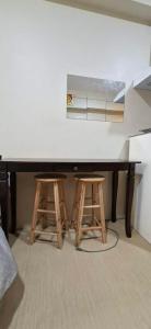 a kitchen table with two stools and a counter top at Avida Towers Aspira Studio Condo in Cagayan de Oro