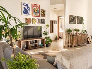a living room with a couch and a flat screen tv at Shamballa - luxury house and apartments in São Miguel do Gostoso