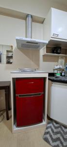 a kitchen with a red cabinet with a stove at Avida Towers Aspira Studio Condo in Cagayan de Oro