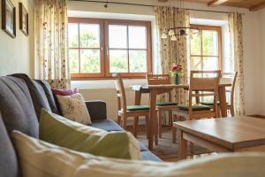 a living room with a couch and a table with chairs at Holzhauser Hof in Waldkraiburg