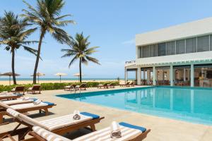 a resort with a swimming pool and palm trees at Jetwing Sea in Negombo