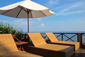 un patio con due sedie e un ombrellone di Villa Boreh Beach Resort and Spa a Tejakula