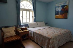 a small bedroom with a bed and a window at A Cup Hostel in Kenting