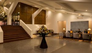 a lobby with people sitting in chairs and a table with flowers at Jetwing Sea in Negombo +49 photos