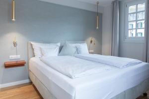 a large white bed in a room with a window at Altes Zollhaus in Beilstein
