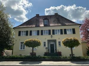 a yellow house with black shutters at VillaWie in Rheda-Wiedenbrück