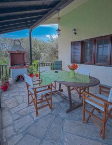 a patio with a table and chairs and a fireplace at Aria Seaview Villa in Vourvourou
