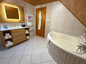 a bathroom with a tub and a sink at Bolla Nyaralóház in Hegyhátszentjakab