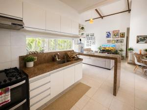 a kitchen with white cabinets and a counter top at Shamballa - luxury house and apartments in São Miguel do Gostoso