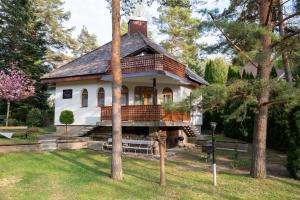 a white house with a porch on a yard at Bolla Nyaralóház in Hegyhátszentjakab