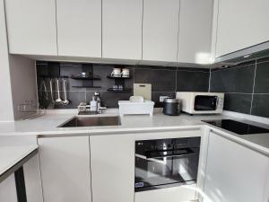 a white kitchen with a sink and a microwave at 광안비치스테이&Spa in Kwangan-dong
