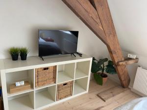 a television on a white cabinet in a room at Annasroom in Kortrijk
