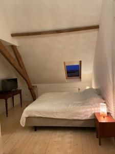 a bedroom with a bed and a television and a table at Annasroom in Kortrijk