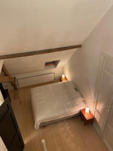 an attic bedroom with a bed and two tables at Annasroom in Kortrijk +6 photos