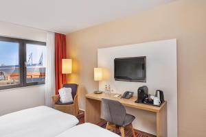 a hotel room with a bed and a desk with a computer at Best Western Hotel Bochum in Bochum