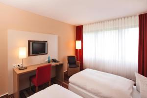 a hotel room with a bed and a desk with a computer at Best Western Hotel Bochum in Bochum +56 photos