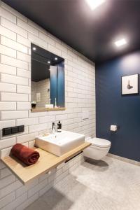 a bathroom with a sink and a toilet and a mirror at ipartment Darmstadt HOME by Best Western in Darmstadt +23 photos