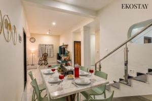 a dining room with a table with glasses of wine at EKOSTAY Gold - Vanamora Villa in Pandhurli