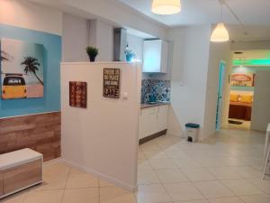 a kitchen with white cabinets and blue walls at Loft Centrico Bahía 5 in Santander +9 photos