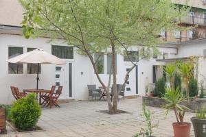 a patio with an umbrella and a table and chairs at Silver Dream Apartmanház in Debrecen