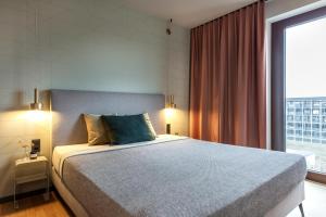 a bedroom with a bed and a large window at ipartment Berlin Airport HOME by Best Western in Schönefeld +24 photos