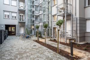 ein Innenhof mit Bäumen vor den Gebäuden in der Unterkunft ipartment Berlin Mitte HOME by Best Western in Berlin