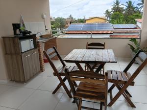 a table and chairs on a balcony with solar panels at Suítes Maanaim Flecheiras in Flecheiras