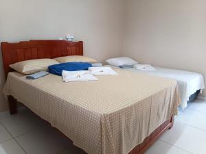 two beds sitting next to each other in a room at Suítes Maanaim Flecheiras in Flecheiras