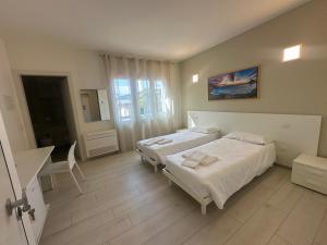 a bedroom with two beds and a sink and a mirror at Locanda Patoea Alloggi in Borgoricco