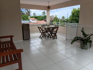 a room with a table and chairs on a balcony at Suítes Maanaim Flecheiras in Flecheiras