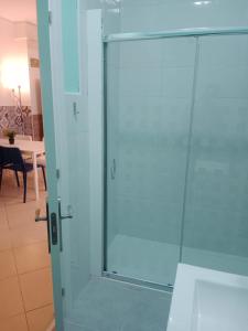 a glass shower door in a room with a table at Loft Centrico Bahía 5 in Santander