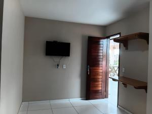 a room with a flat screen tv on a wall at Suítes Maanaim Flecheiras in Flecheiras