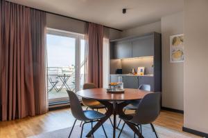 ein Esszimmer mit Tisch und Stühlen und einem großen Fenster in der Unterkunft ipartment Berlin Mitte HOME by Best Western in Berlin