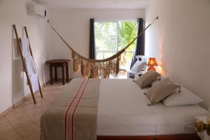 a bedroom with a bed in a room with a window at WishTulum in Tulum