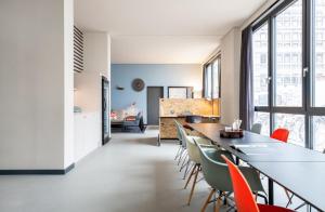 a kitchen and dining room with a long table and chairs at ipartment Braunschweig HOME by Best Western in Braunschweig