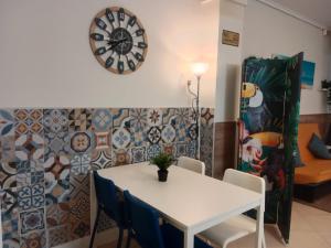 a dining room with a table and a clock on the wall at Loft Centrico Bahía 5 in Santander