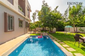 a swimming pool in the backyard of a house at EKOSTAY Gold - Vanamora Villa in Pandhurli +26 photos