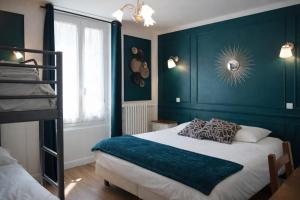 a bedroom with a bed with a blue wall at L'Harmony in Saint-Arnoult-en-Yvelines