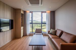 a living room with a couch and a large window at ILLITE Hotel in Yŏngdong