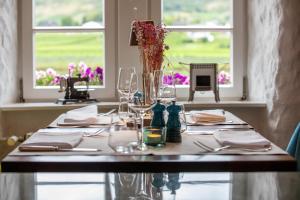 a table with glasses and a vase on top of it at Altes Zollhaus in Beilstein