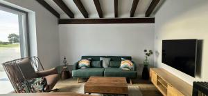 a living room with a green couch and a tv at Quinta Cuadrao in Cartavio