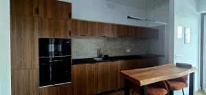 a kitchen with a black refrigerator and wooden cabinets at Quinta Cuadrao in Cartavio +15 photos