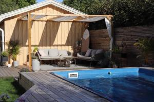 a pavilion with a swimming pool in a backyard at Villa med Pool in Stockholm