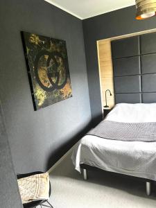 a bedroom with a bed and a painting on the wall at Villa med Pool in Stockholm +20 photos