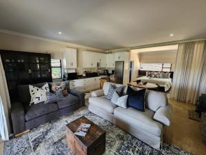 a living room with two couches and a kitchen at Fairfax Studio in Nottingham Road